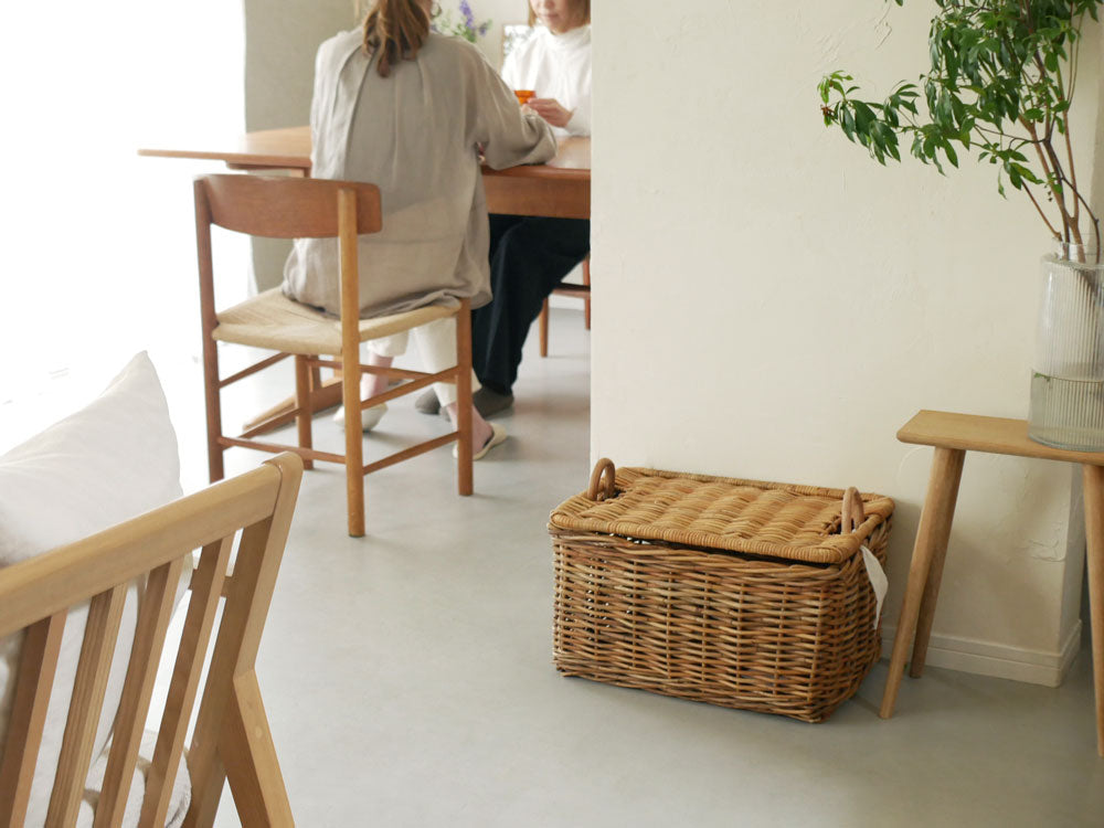 木製フローリングの上に置かれたインドネシア製の皮つきラタン運べる収納バスケット『Creer/クレエ』