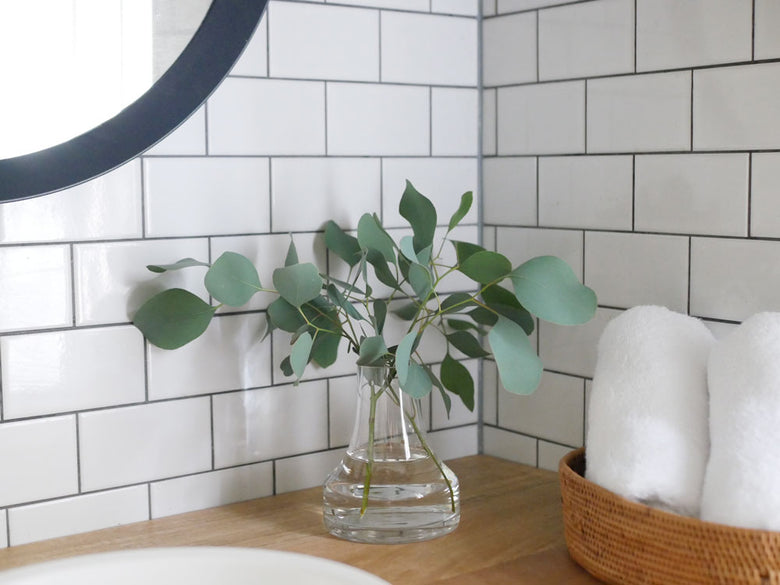 BOB CRAFT製ソーダガラスの灰色浴室用水栓『ファゴット』がタイル上に配置された静物写真