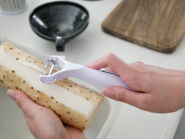 クレバー社のクレバースライサーと野菜やチーズがまな板の上に配置されているキッチン用品の写真