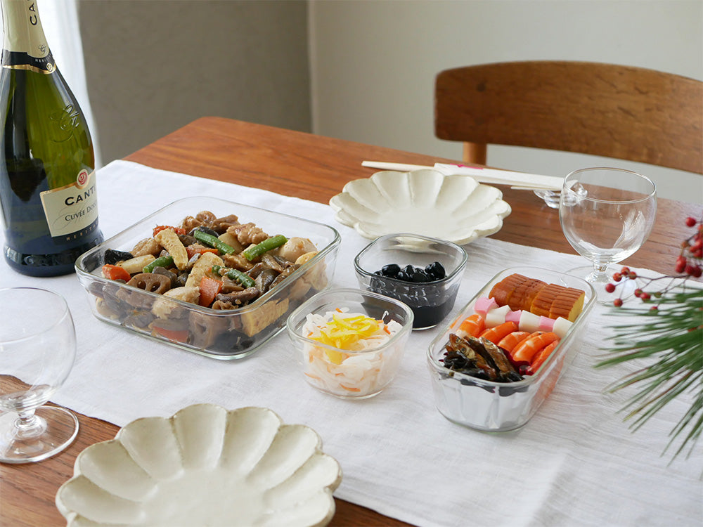 イワキのパック&レンジ システムセットを使用して盛り付けられた料理と食器がテーブルに並んでいる様子