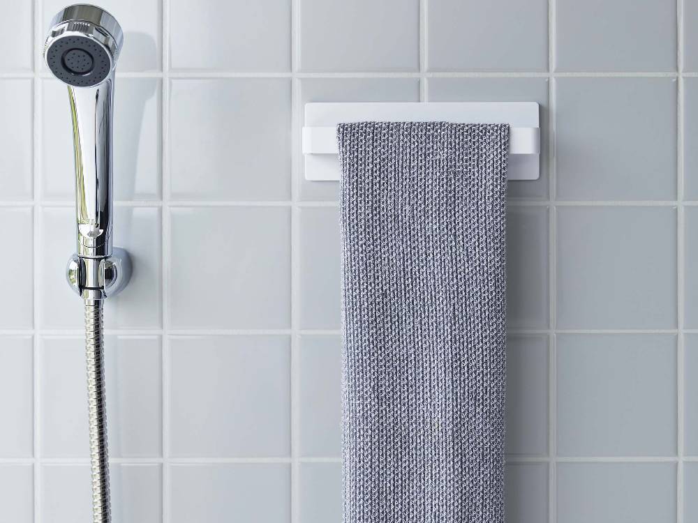 MIST（ミスト）フィルムフックタオルハンガーW18が浴室の壁に設置され、銀色のタオルが掛けられている様子