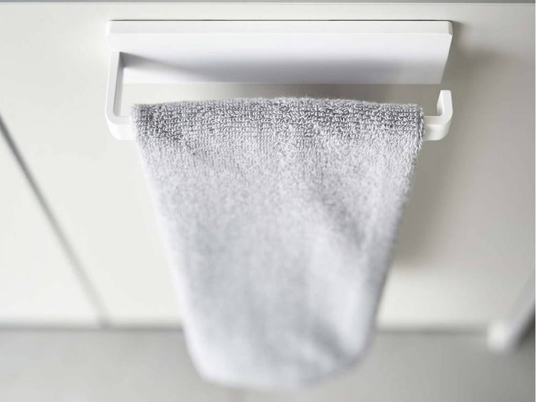 【MIST/ミスト】フィルムフック タオルハンガー W18が光沢のある壁面に取り付けられ、タオルを掛けている様子
