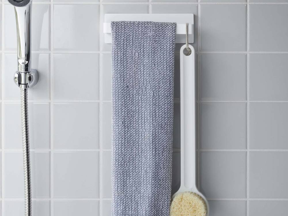 浴室のステンレス壁に取り付けられたMIST/ミストフィルムフック タオルハンガー W18にタオルや布巾が掛かっている様子