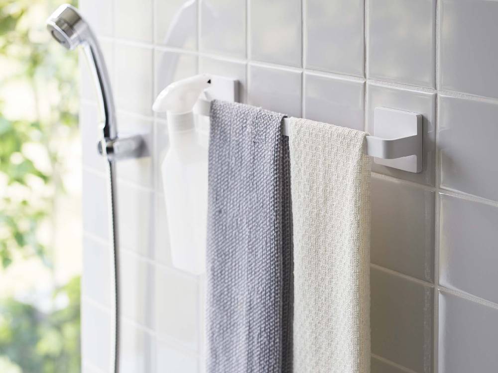 銀色のミスト製フィルムフック タオルハンガーが浴室の壁に取り付けられ、タオルを掛けている様子