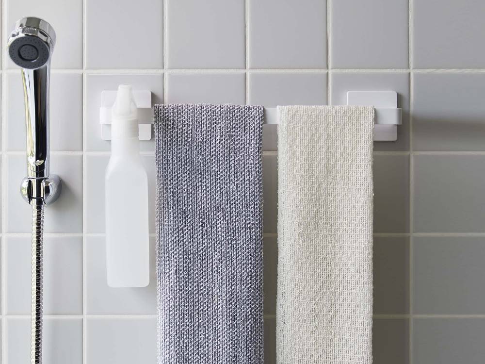 浴室の白い壁に幅36cmのMIST（ミスト）フィルムフック タオルハンガーが取り付けられており、タオルが掛けられている様子