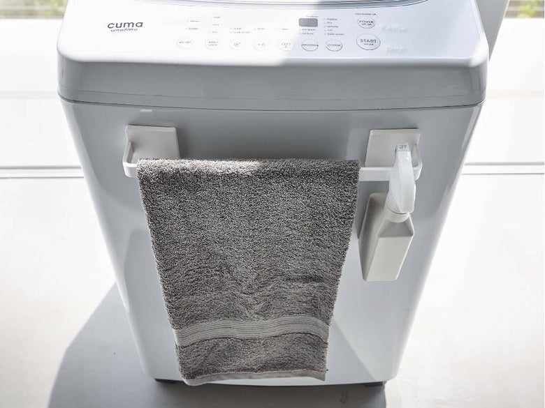 洗濯機や衣類乾燥機、シンクが配置された洗面所に、MISTフィルムフック タオルハンガーが設置されている様子