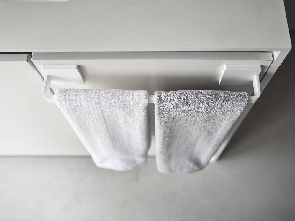 ABS樹脂製の【MIST/ミスト】フィルムフック タオルハンガー W36が平らな壁面に取り付けられ、タオルを掛けている様子