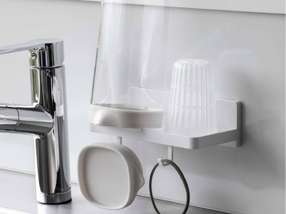 キッチンの棚に取り付けられた【MIST/ミスト】フィルムフック トレー W18。蛇口や観葉植物、花瓶などの家庭用品を整理しています。