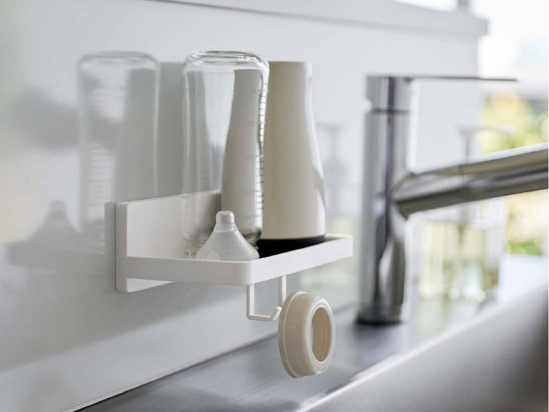 洗面台横の壁に取り付けられたシルバーのプラスチック製【MIST/ミスト】フィルムフック トレー W18が洗面用品を整理している様子