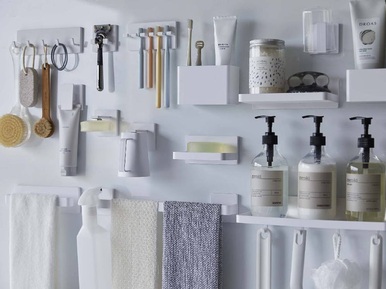 【MIST/ミスト】フィルムフック トレー W18が浴室の棚に取り付けられ、ボトルや歯ブラシホルダー、タオルなどの生活用品が整然と配置されています。