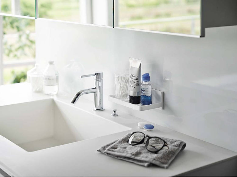 バスルームのシンク台に【MIST/ミスト】フィルムフック トレー W18が設置され、蛇口やボトルが整理されている様子