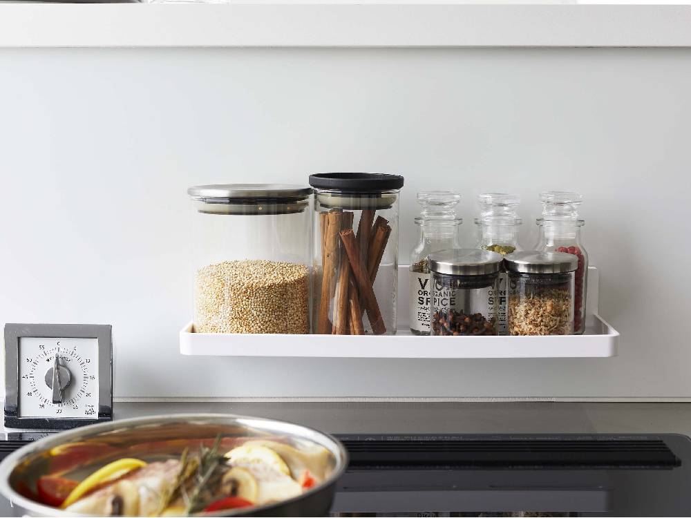 キッチンの棚に設置された【MIST/ミスト】フィルムフック トレー W30。食品保存容器や調理器具が整理されています。
