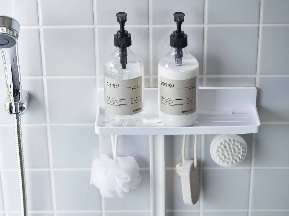 浴室の洗面台に【MIST/ミスト】フィルムフック トレー W30が設置され、ソープディスペンサーやタオル、歯ブラシホルダーなどの家庭用品が整然と配置されている様子