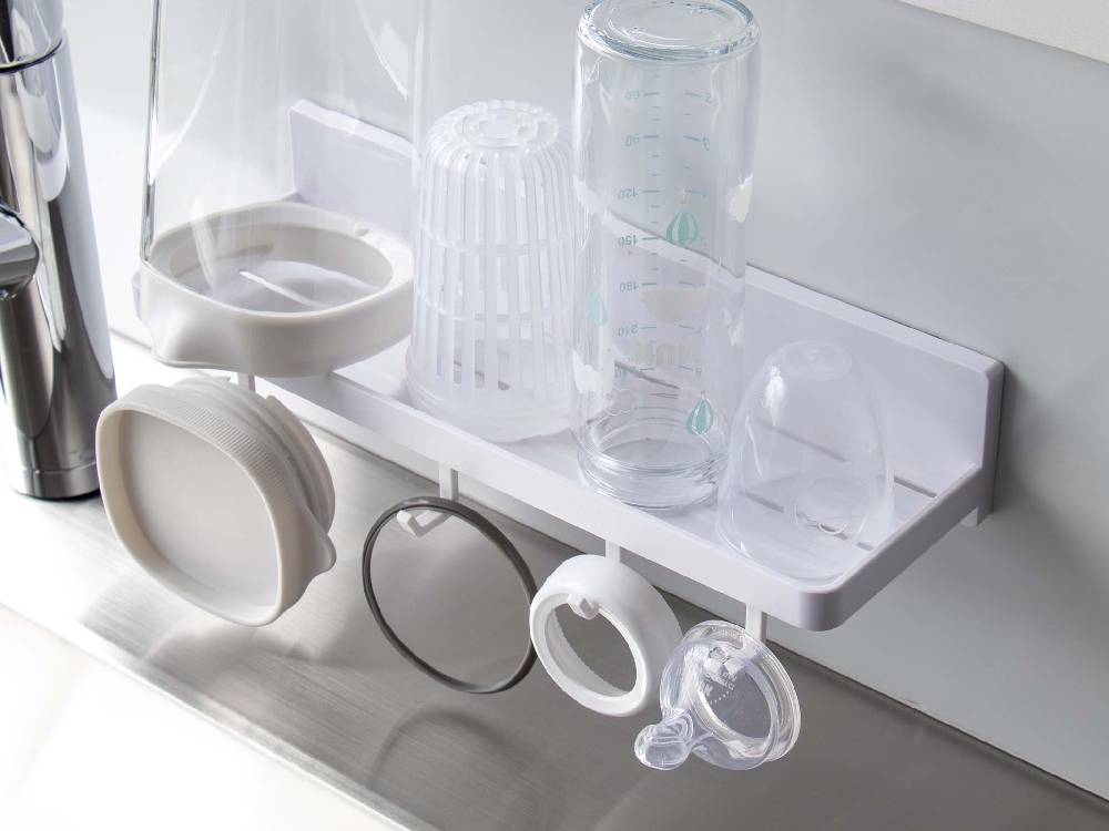 ミストのフィルムフック トレー W30がキッチンの棚に取り付けられ、食器やカトラリーが整理されている様子