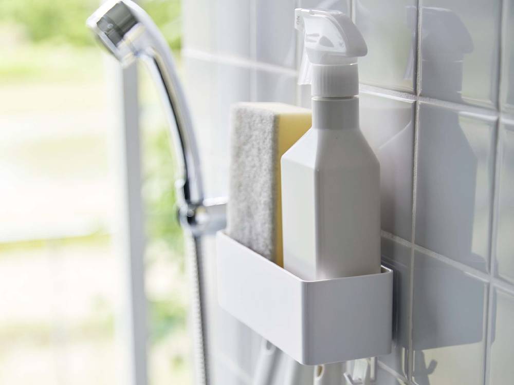 バスルームのシンク周りに配置された水栓、石鹸ディスペンサー、ボトルなどの浴室設備