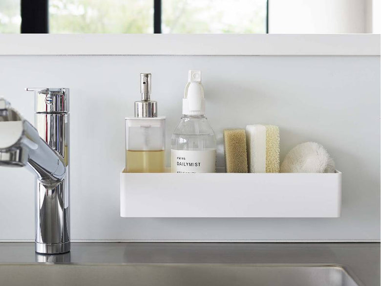 バスルームの洗面台上に配置されたボトル、石鹸ディスペンサー、蛇口、収納キャビネットが見えるシーン