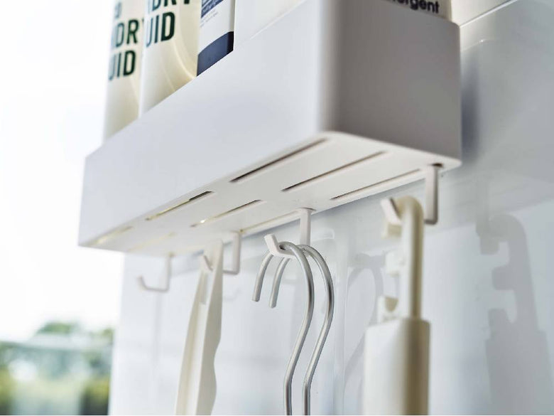 光沢のある壁に幅30cmの【MIST/ミスト】フィルムフックラックが棚と洋服ハンガーを備えてスタイリッシュに設置されたインテリア