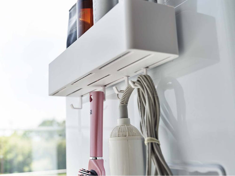 ミストフィルムフックラックW30に家庭用家電、パイプ、電気ケーブル、観葉植物が掛けられている室内の様子