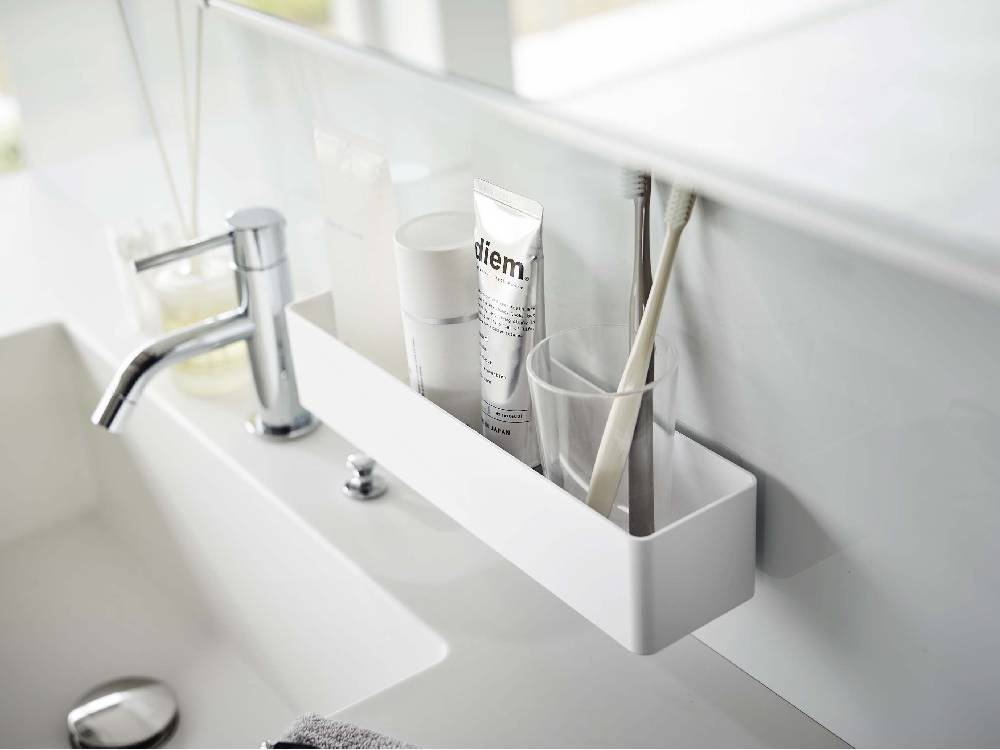 バスルームのシンクに設置された『MIST ミスト フィルムフック ラック W30』。フィルムフックにボトルやバス用品が掛けられている様子。