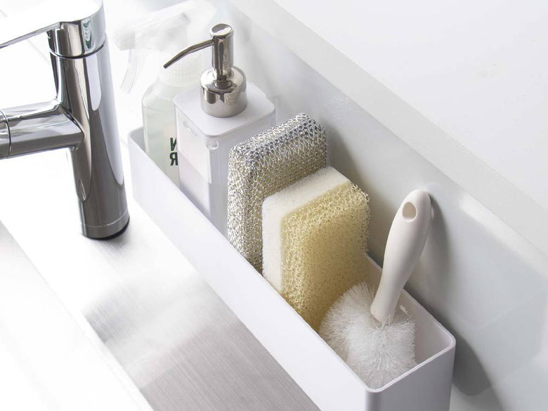 浴室の洗面台に「MIST/ミスト フィルムフック ラック W30」が設置され、歯ブラシホルダーやソープディスペンサーなどの日用品が掛けられている様子。