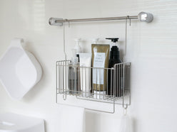 バスルームのシンク上に掛けられた18-8ステンレス製の引っかけ式バスケットと、ボトルや石鹸ディスペンサー、歯ブラシホルダーが整然と配置されている様子