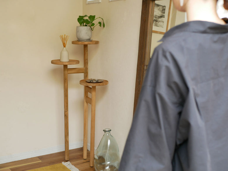 チーク無垢材製のサンフラワーラタンステップトレイテーブルに観葉植物を載せた画像