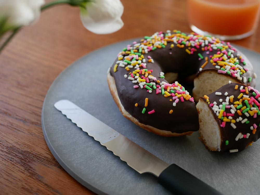 CHOPLATEのまな板になるお皿にカラフルなドーナツやベーグルが並べられたテーブル