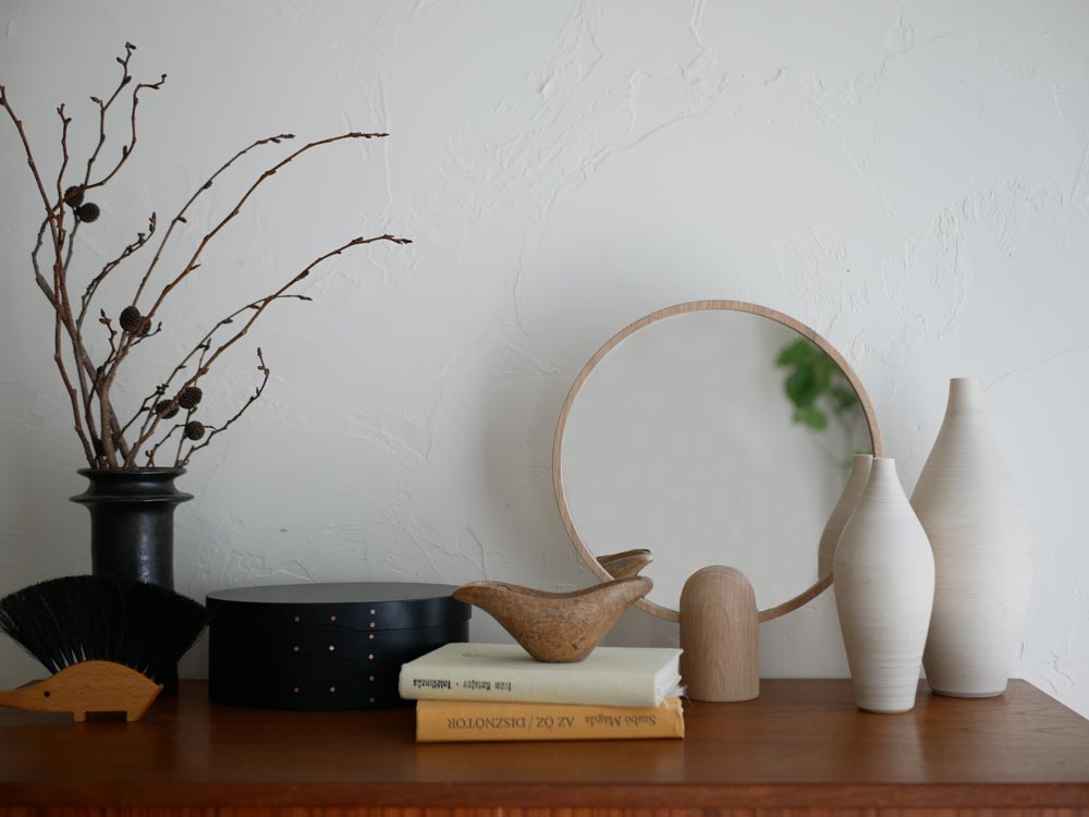 フリッツ・ハンセン Skagerak Aino ミラーと陶器の花瓶、ランプが並べられた静物写真