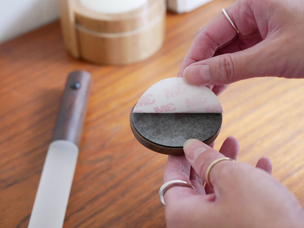 オプトの木製とアクリル樹脂製スティックセンサーライトがオフィス用品やキッチン用具と共に配置された写真