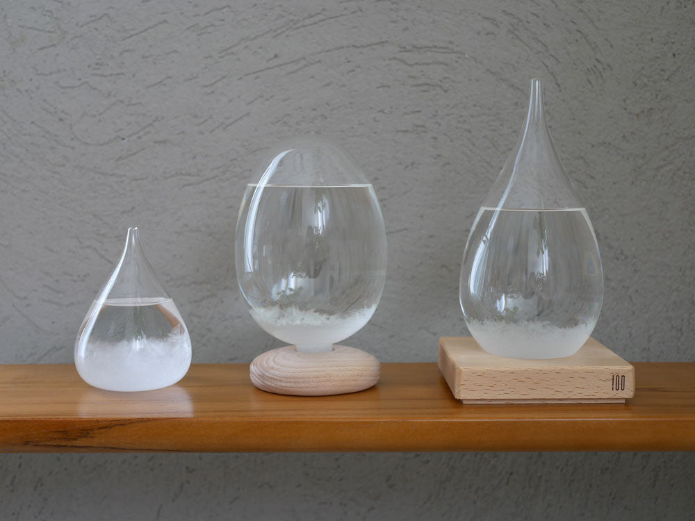 透明なガラス製の花瓶に銀の装飾が施され、木製の台座に置かれた静物写真