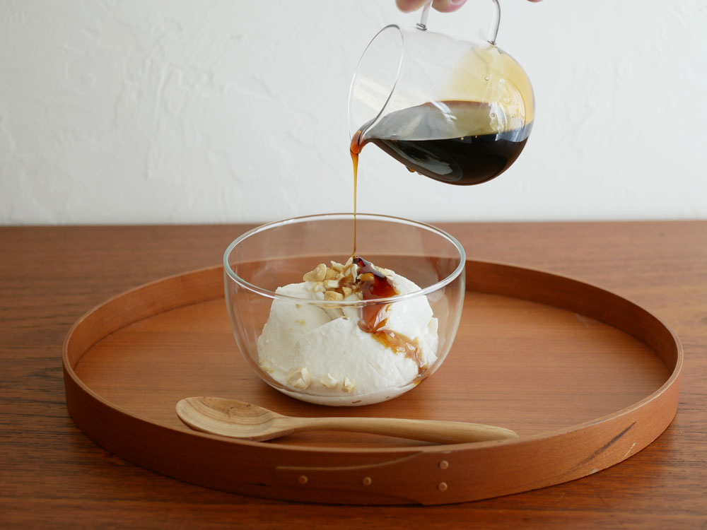 台湾製の耐熱ホウケイ酸ガラスアイスクリームボウル、サラダボウル、プディングカップが木製のテーブルに美しく並べられている