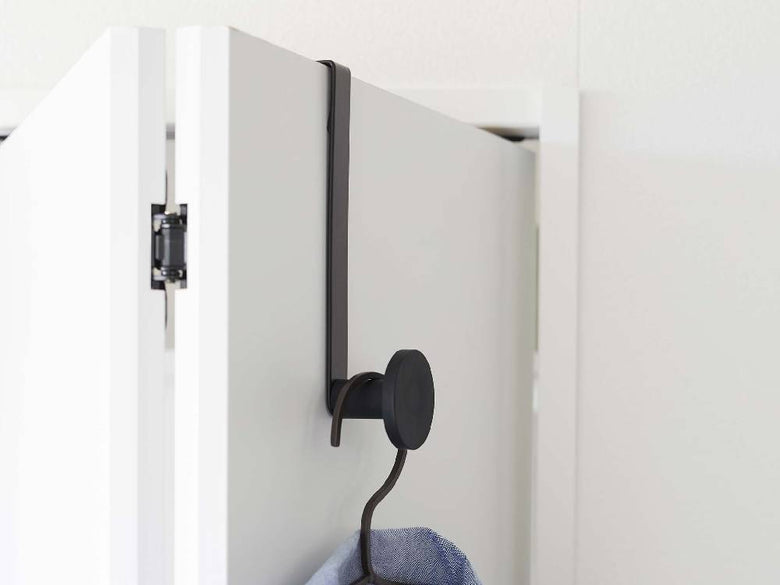 スチール製の滑り止め付きスマートドアハンガーが一般的な平面ドアに取り付けられている様子。幅5cm、高さ19.5cmでホンカラのシリコーンフックが見える。