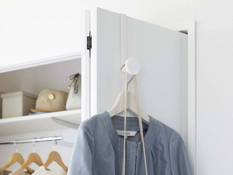 滑り止め付きスマートドアハンガーがスチール製のドアに取り付けられ、衣類が掛けられている様子。幅約5cm、高さ約19.5cm。