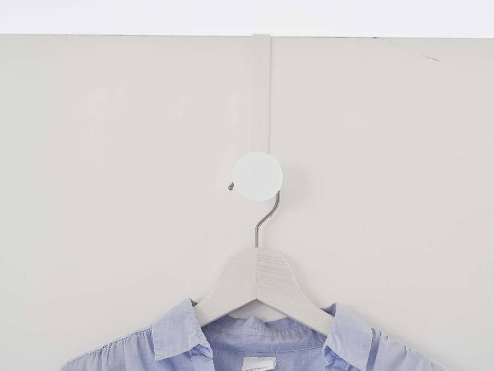 白色の滑り止め付きスマートドアハンガーがドアに掛かっている様子