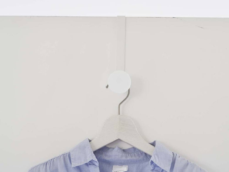 白色の滑り止め付きスマートドアハンガーがドアに掛かっている様子