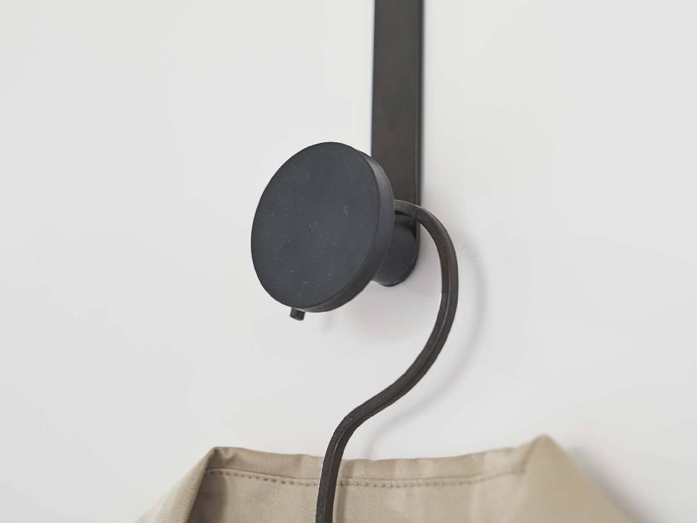 滑り止め付きドアハンガーが室内のドアに掛けられ、照明器具と電気ケーブルが周囲に配置されている様子