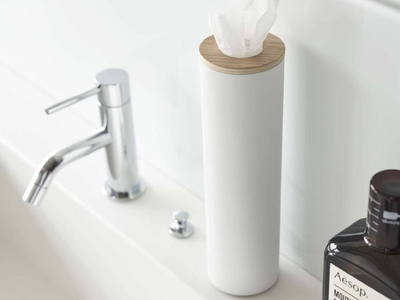 スチールと天然木の蓋を持つボトル型ティッシュケースがバスルームの洗面台に置かれている