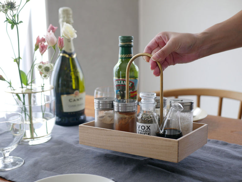 テーブルにSkagerak Norr Carrierが置かれ、ガラス瓶や果物、キッチン用品が並べられている様子