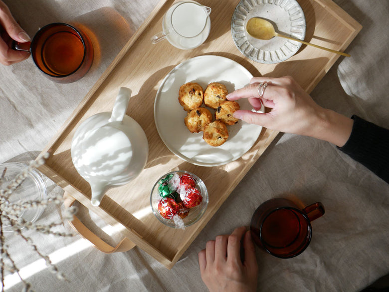 フリッツ・ハンセンのオークとレザースカゲラックノールトレイに並べられた陶器製のプレートとボウル