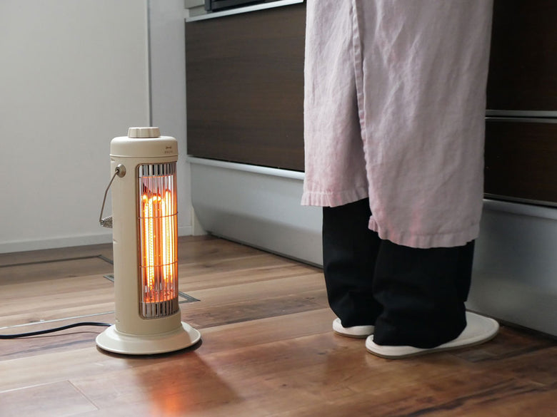 BRUNOのノスタルジックなミニカーボンヒーターが木製フローリングの上に置かれている様子