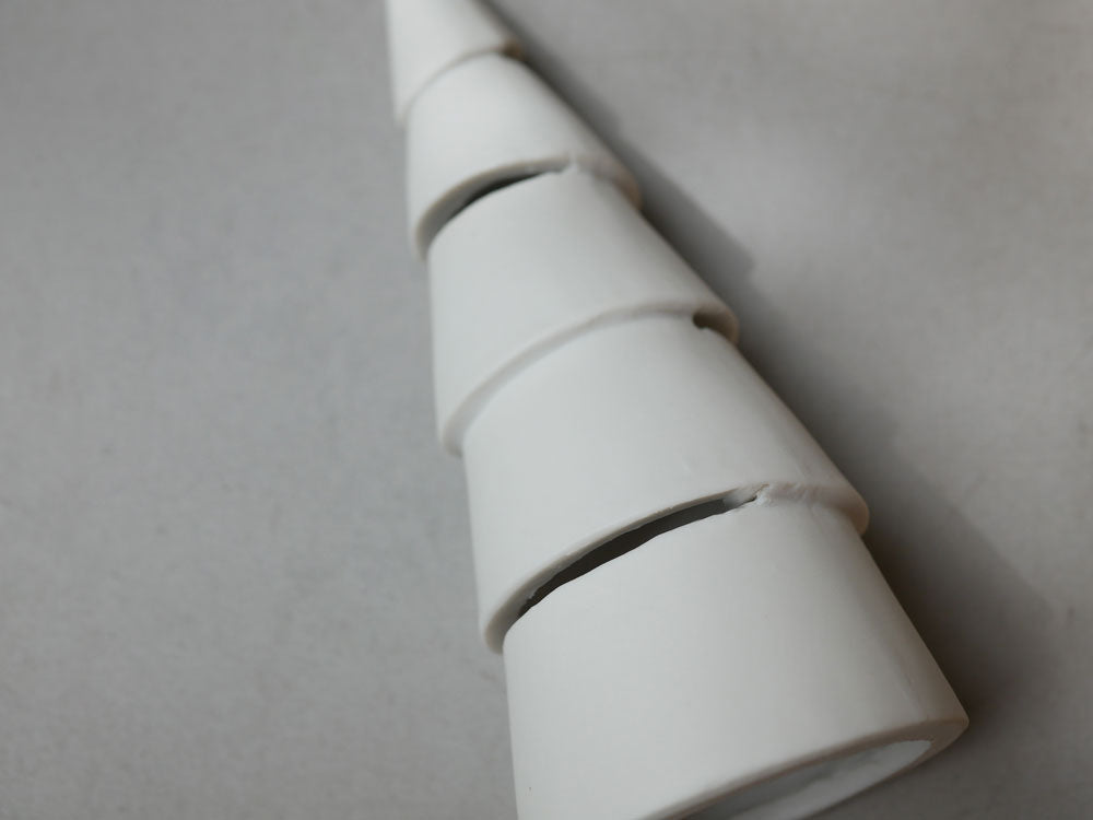 九谷焼のクリスマスツリーにプラスチック製の円錐型と円筒型LEDキャンドルが飾られている様子