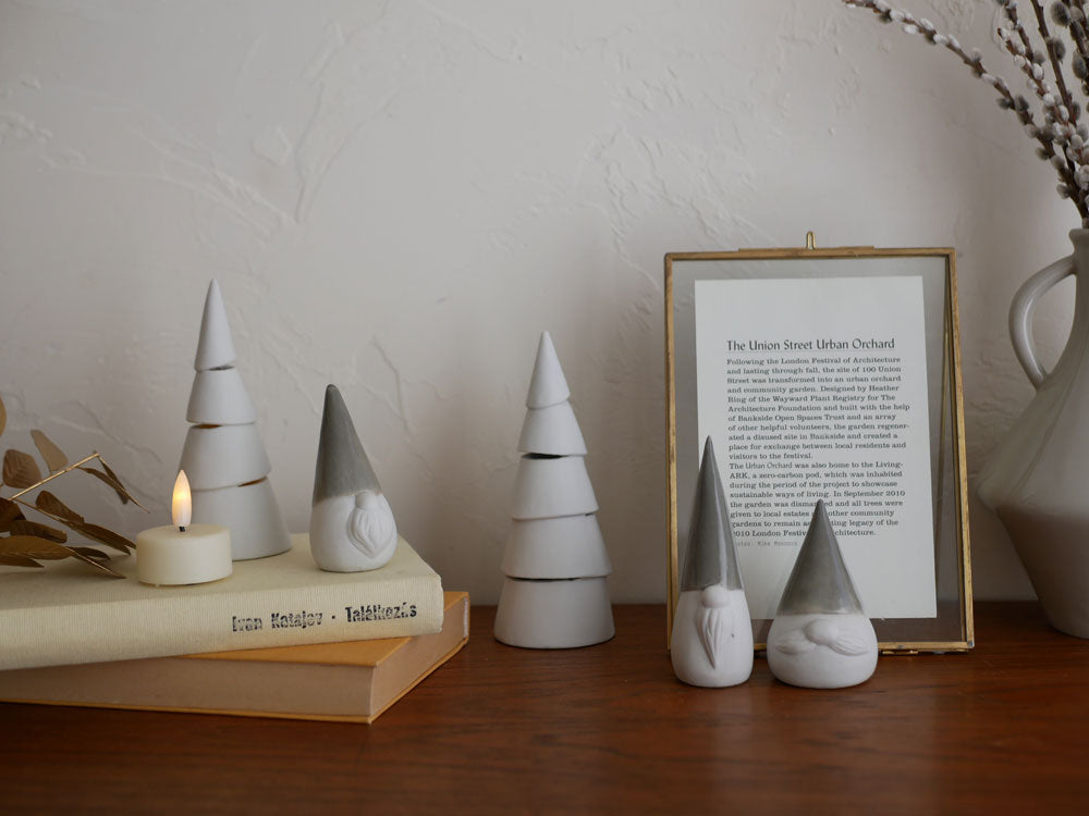 灯りが漏れる九谷焼の円錐形クリスマスツリーにLEDキャンドルが灯る静物写真。自然素材とクラフトのディテールが特徴です。