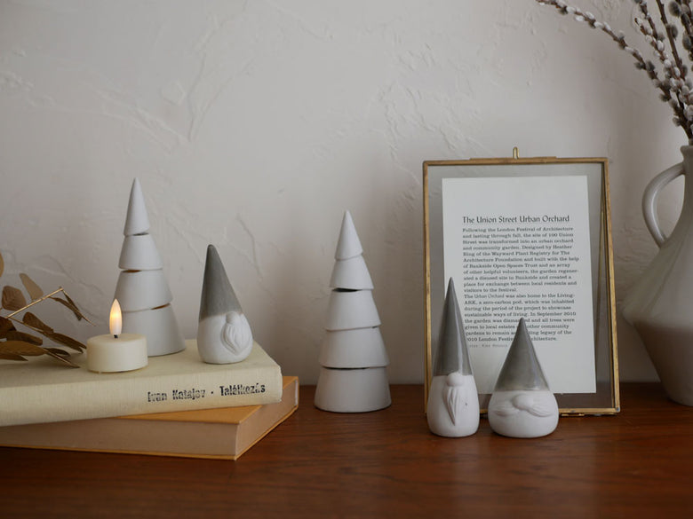 灯りが漏れる九谷焼の円錐形クリスマスツリーにLEDキャンドルが灯る静物写真。自然素材とクラフトのディテールが特徴です。