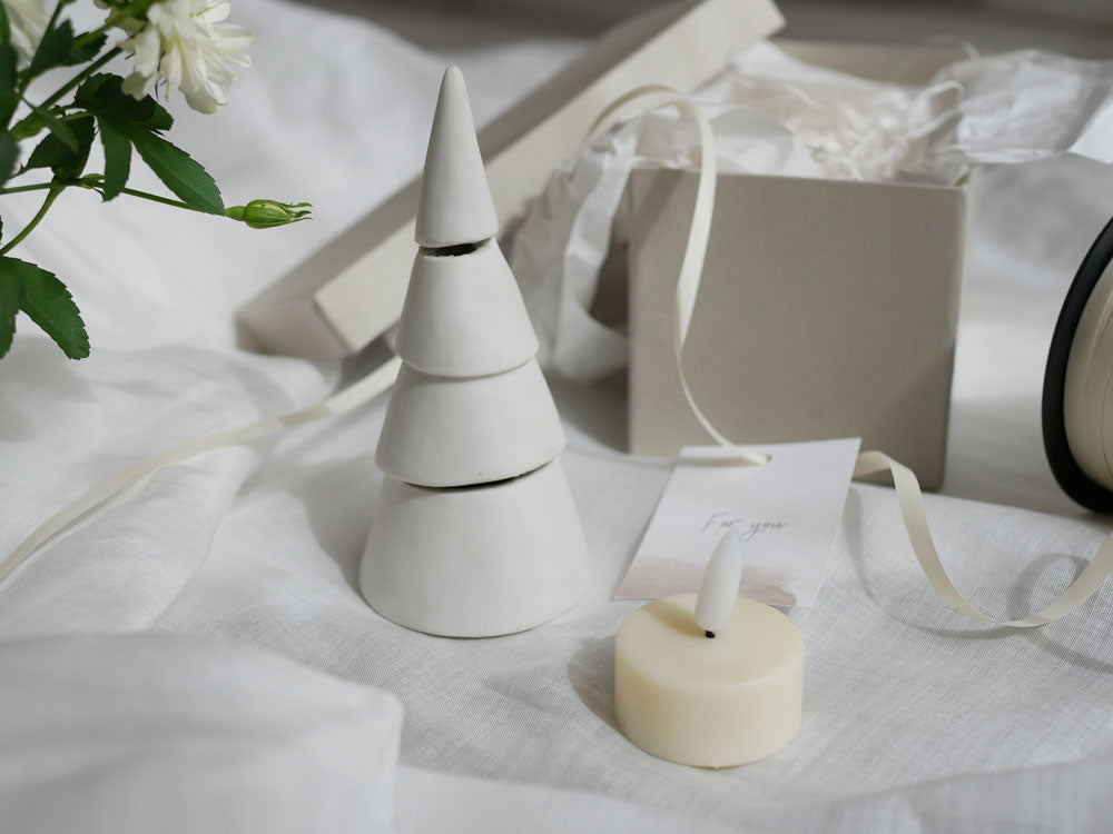 九谷焼のクリスマスツリーに紙製のコーン飾りとLEDキャンドルが灯り、柔らかな光を放つ陶磁器製ツリー