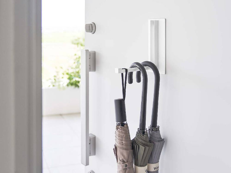 白色のマグネット折り畳みハンガーが壁に取り付けられている様子
