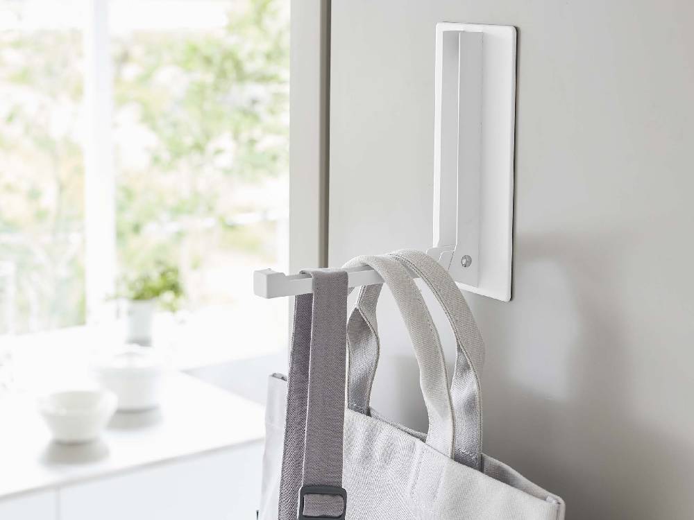 タワーの白色マグネット折り畳みハンガーがスチール製の壁面に取り付けられており、滑り止めシリコーンが見える様子。