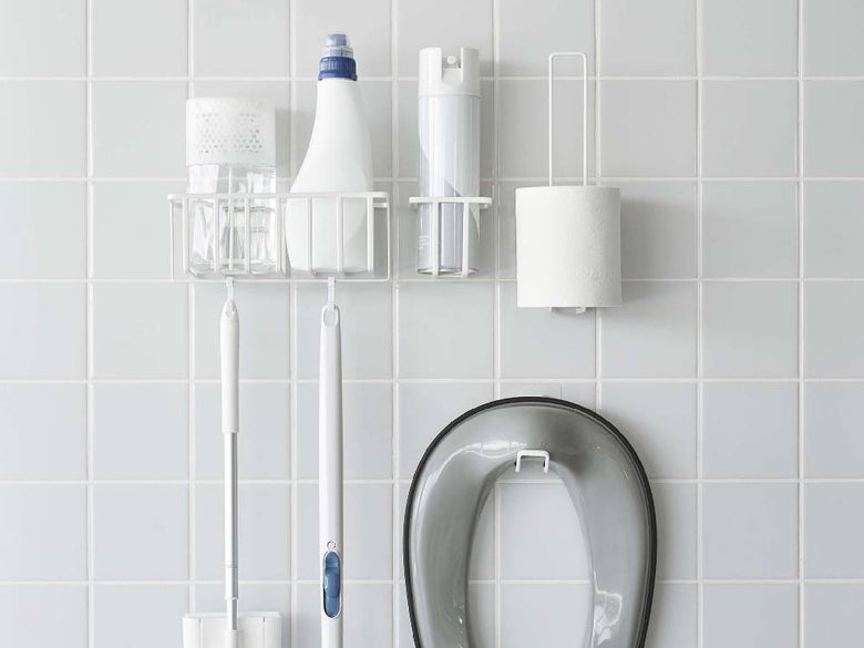 シルバー仕上げの【tower/タワー】フィルムフックトイレットペーパーホルダーがバスルームの壁に取り付けられている様子。スチール製でシンプルなデザイン。