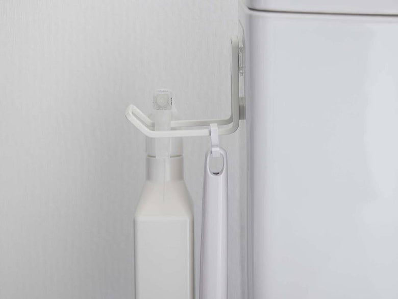 タワーのフィルムフックトイレ用品収納フックが浴室の洗面台近くの壁に取り付けられ、洗面用具やタオルが掛けられている様子