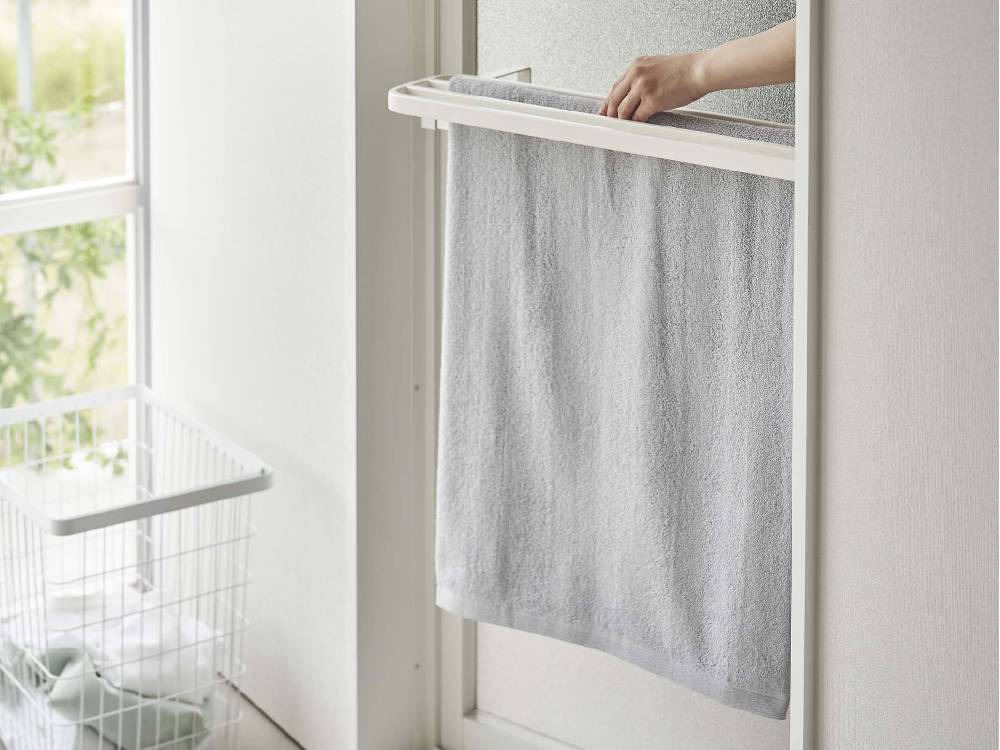 銀色のスチール製【tower/タワー】浴室扉タオル掛け上。複数のバスタオルハンガーとシェルフが組み込まれ、浴室内でタオルやリネン類を整理整頓できるデザイン