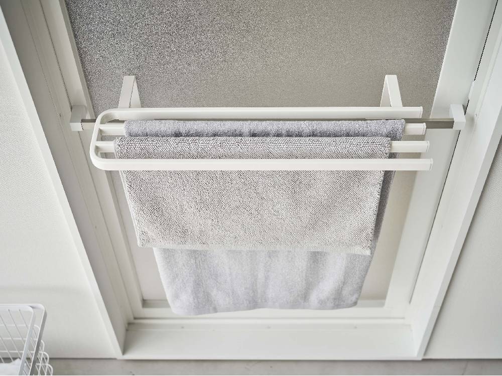 浴室扉に取り付けられた銀色のステンレス製タオルハンガーに複数のタオルが掛かっている様子